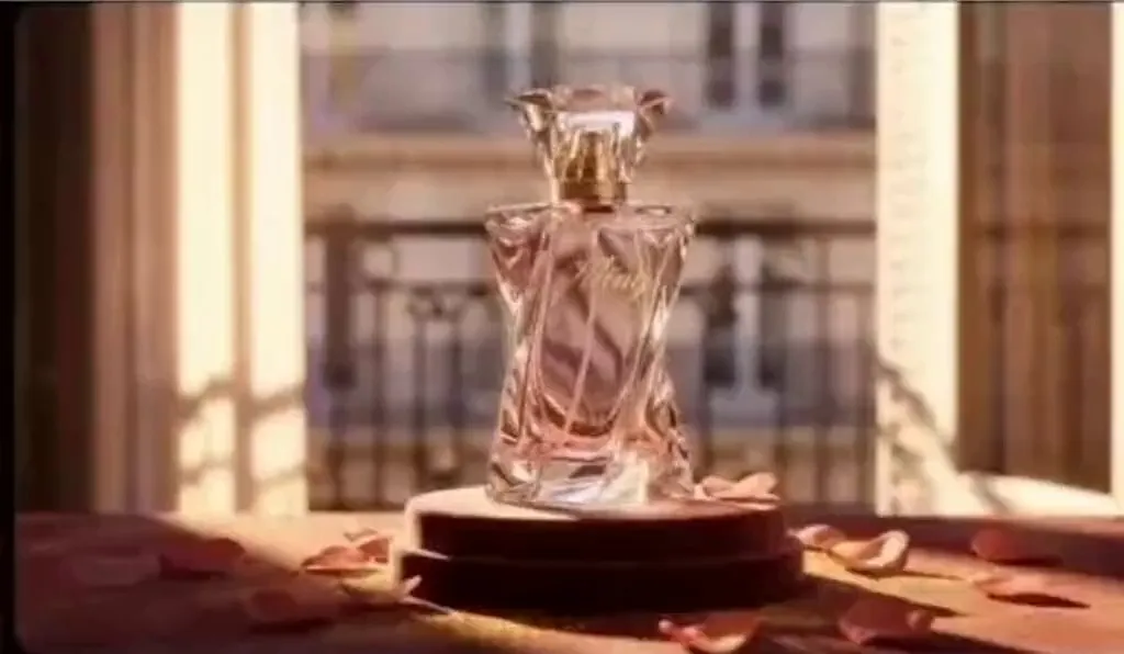 kling 3.0 smart storyboard | Parisian apartment window scene with soft French piano BGM. Golden afternoon sunlight filters through blinds onto a perfume bottle, creating dappled shadows. Camera slowly pushes in from scattered rose petals, focusing on the cut facets of the Kling perfume bottle. Voiceover (languid French female voice, British accent, slow pace): Bathe in the golden hour. Camera slow-motion orbits the perfume bottle, capturing the gold engraving and light flowing across the bottle. Voiceover: Kling, a whisper of Parisian elegance. Camera pulls back to frame the complete scene (perfume bottle on velvet pedestal, Parisian buildings visible through the window). Voiceover: Wrap yourself in luxury with every breath.